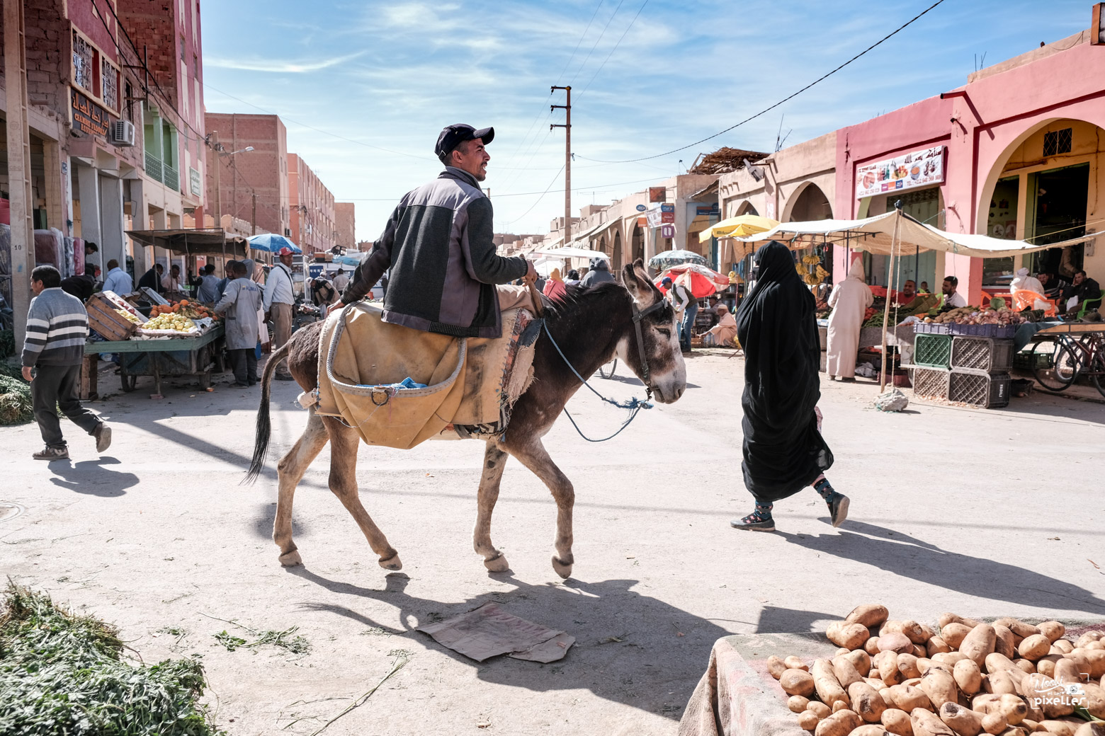 Un homme sur le dos d'un âne dans une rue du souk